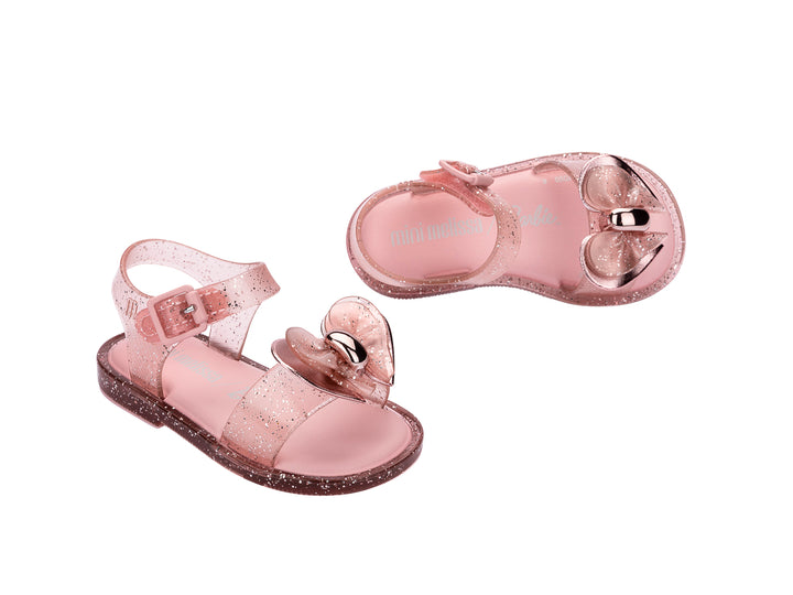 Par de sandalias Mini Melissa color rosa brillante con detalle de moño y correa ajustable para niña.