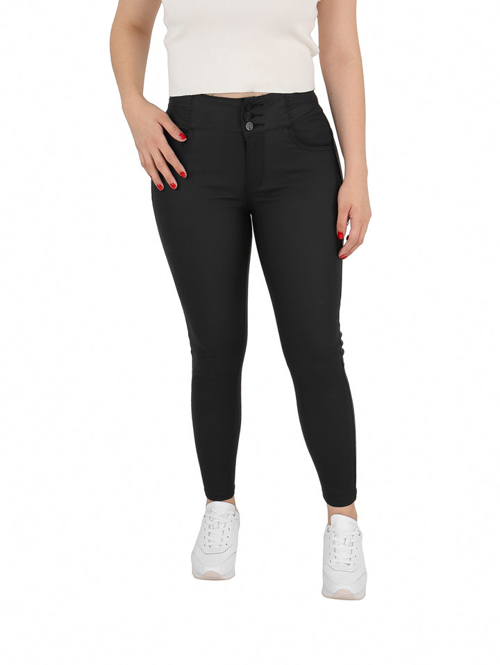 Mujer vistiendo un pantalón negro ajustado de piel sintética y tenis blancos.