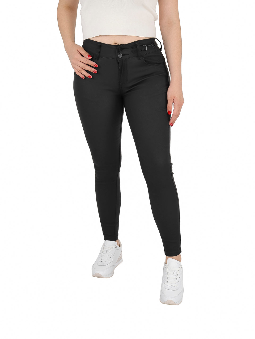 Mujer vistiendo un pantalón ajustado de vinipiel color negro con tenis blancos.