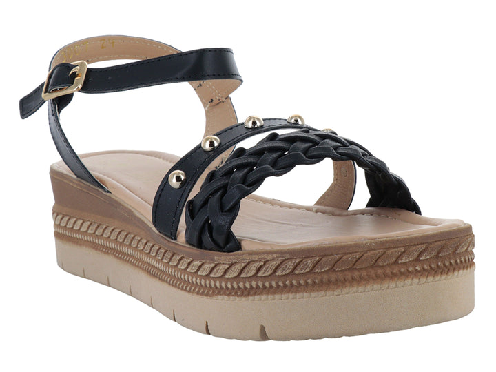 Sandalias negras de plataforma con correa trenzada, detalles dorados y suela beige para mujer.