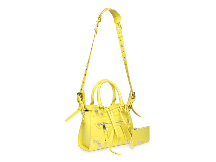 Bolso de mano amarillo de Steve Madden con asas superiores y correa larga ajustable.