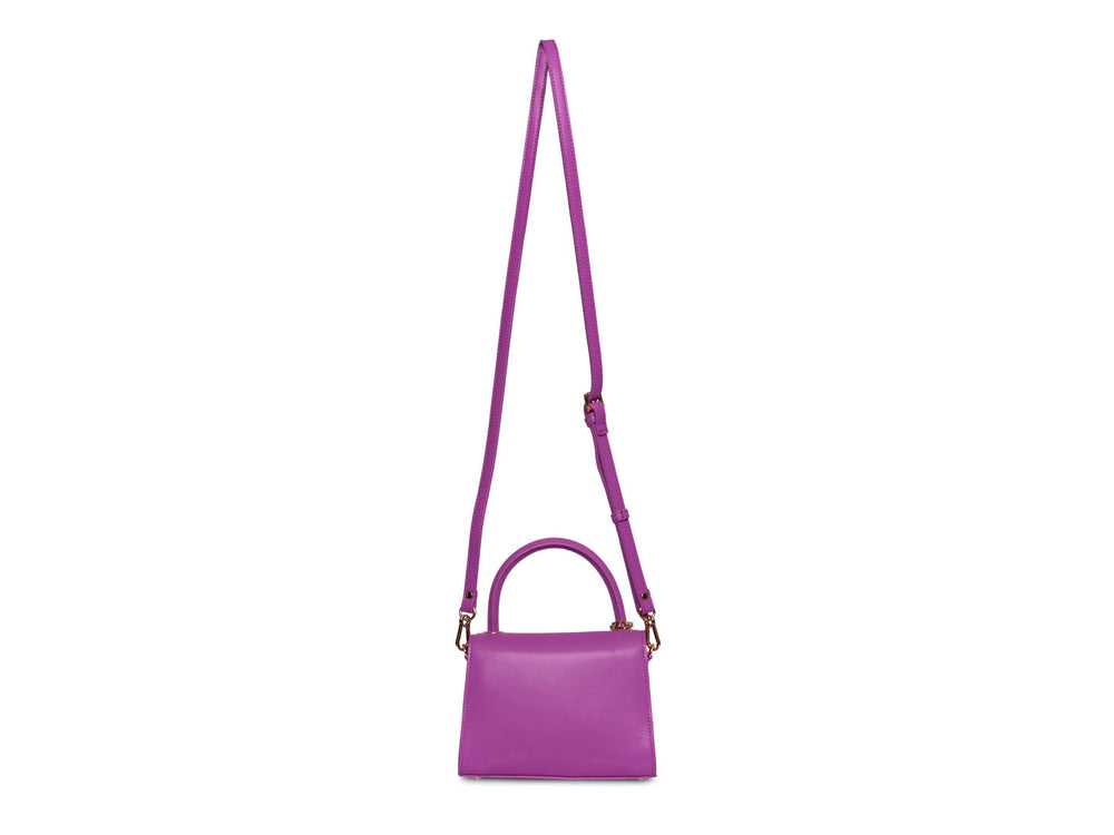 Bolso Steve Madden color rosa con asa circular y detalle de cadena dorada colgante.