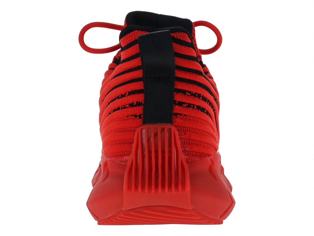 Tenis deportivos rojos con rayas negras y suela gruesa esculpida.