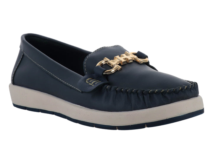 Zapato tipo mocasín azul con suela blanca y detalle metálico dorado en la parte superior.