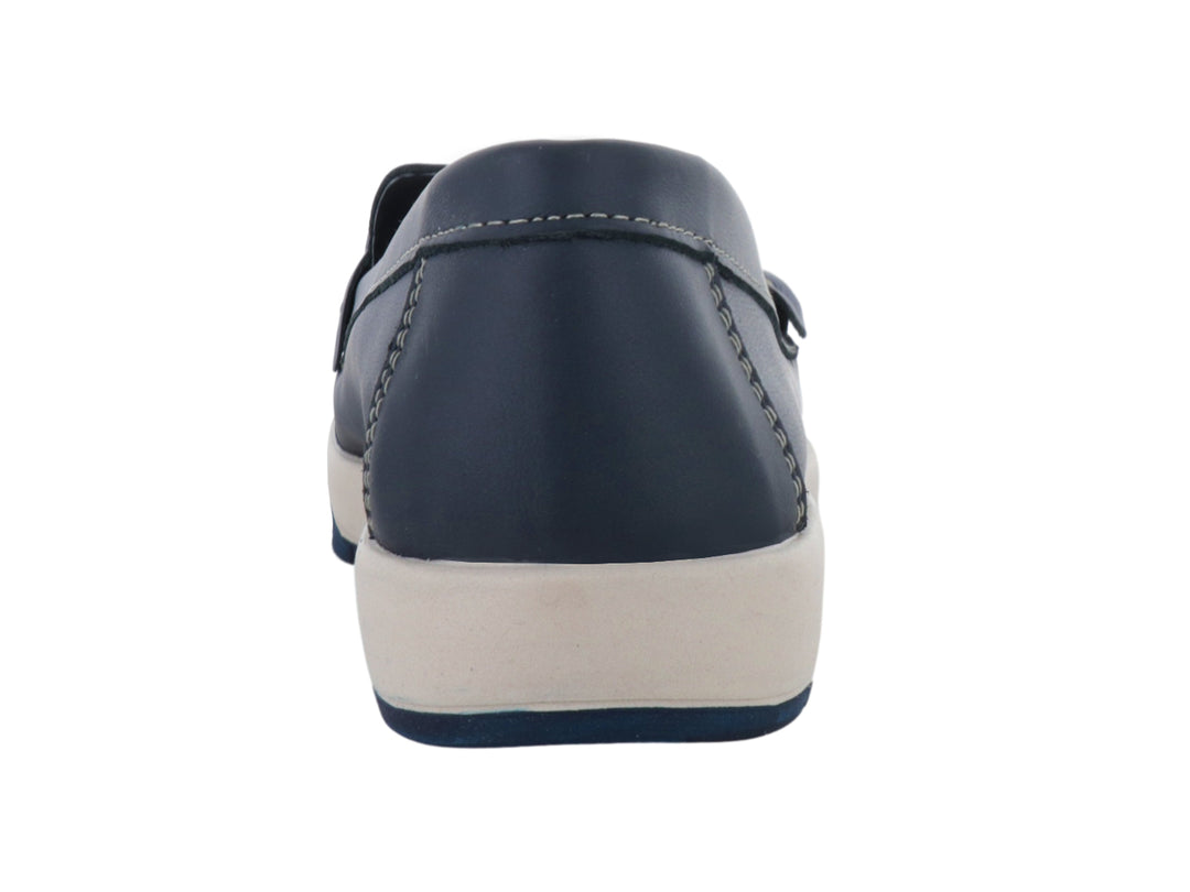 Zapato tipo mocasín azul con suela blanca y detalle metálico dorado en la parte superior.