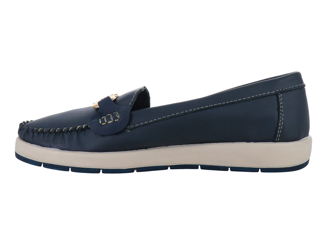 Zapato tipo mocasín azul con suela blanca y detalle metálico dorado en la parte superior.