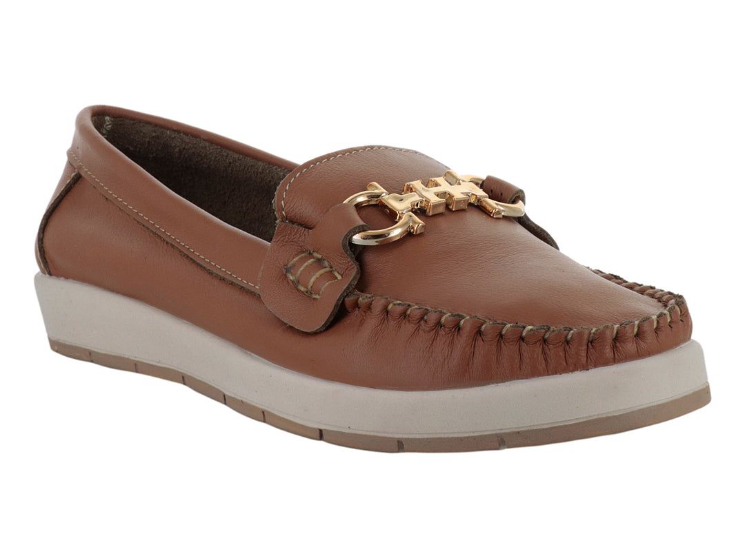 Zapato mocasín color miel con suela blanca y detalle metálico dorado en la parte superior.