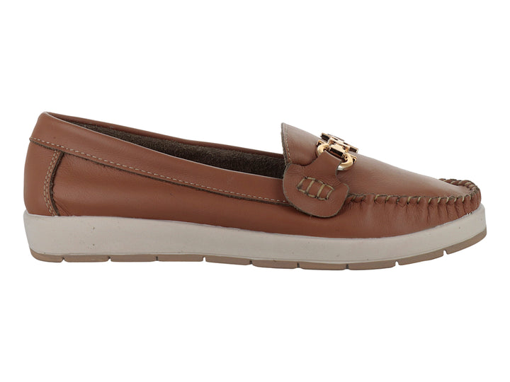 Zapato mocasín color miel con suela blanca y detalle metálico dorado en la parte superior.