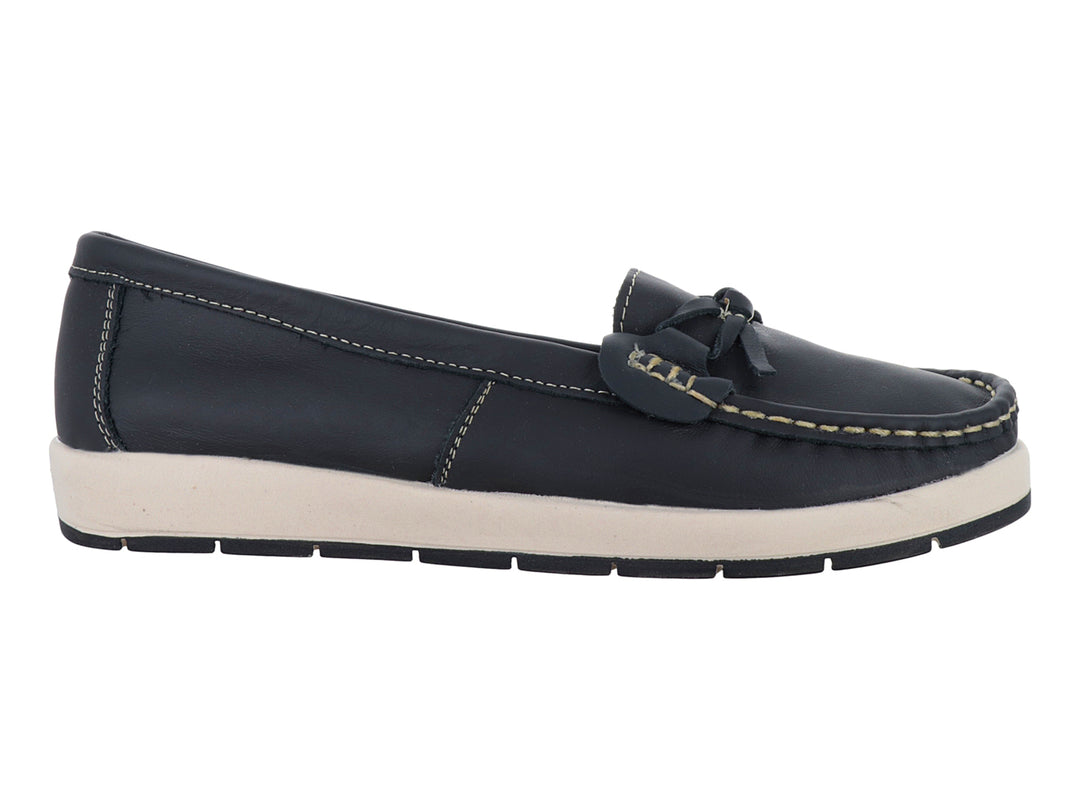 Zapato tipo mocasín color negro con suela blanca y costuras decorativas en color beige.