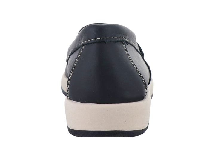 Zapato tipo mocasín color negro con suela blanca y costuras decorativas en color beige.