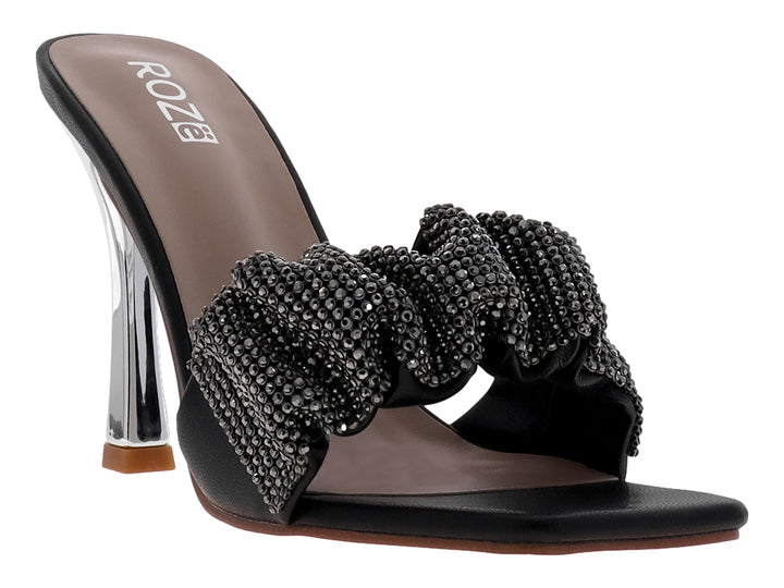 Sandalia negra de tacón grueso transparente con tira frontal adornada con pedrería negra brillante.