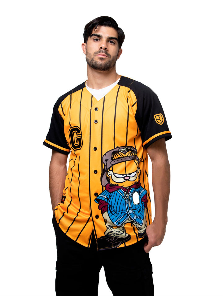 Detalle de la manga de un jersey de béisbol color negro y naranja con un parche de pelota blanca.