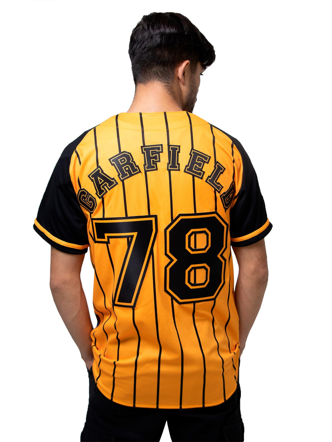 Detalle de la manga de un jersey de béisbol color negro y naranja con un parche de pelota blanca.