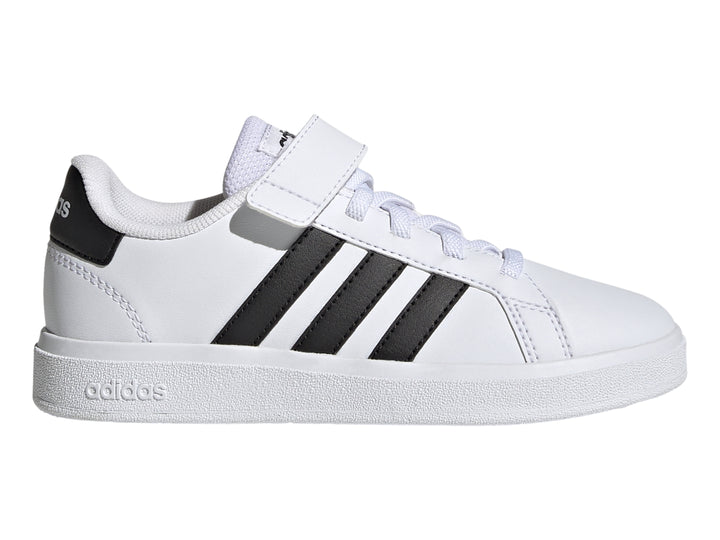 Tenis Adidas blancos con tres franjas negras y correa de velcro.
