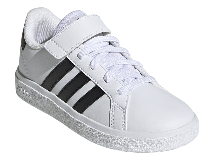 Tenis Adidas blancos con tres franjas negras y correa de velcro.