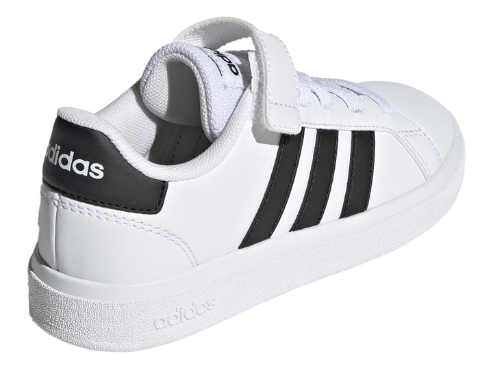 Tenis Adidas blancos con tres franjas negras y correa de velcro.