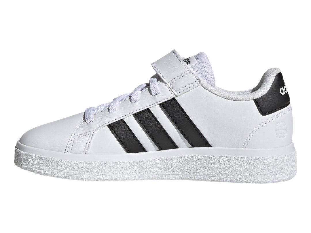 Tenis Adidas blancos con tres franjas negras y correa de velcro.