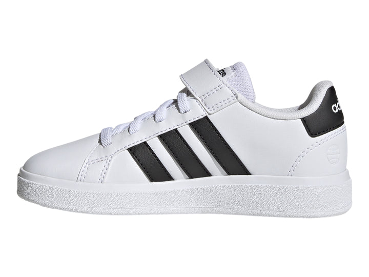 Tenis Adidas blancos con tres franjas negras y correa de velcro.