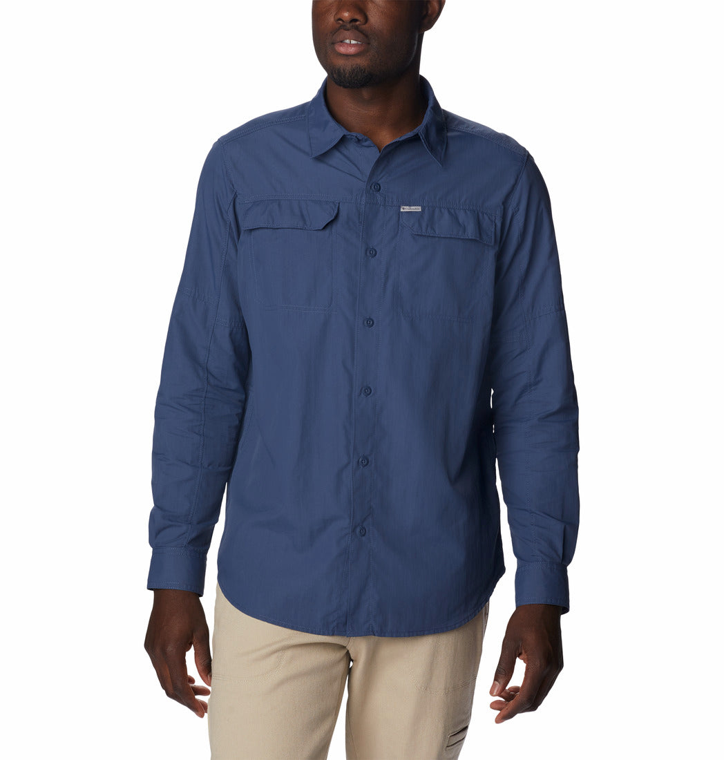 Hombre vistiendo una camisa Columbia de manga larga en color azul oscuro y pantalones color beige.