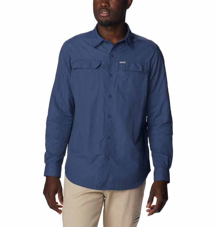 Hombre vistiendo una camisa Columbia de manga larga en color azul oscuro y pantalones color beige.