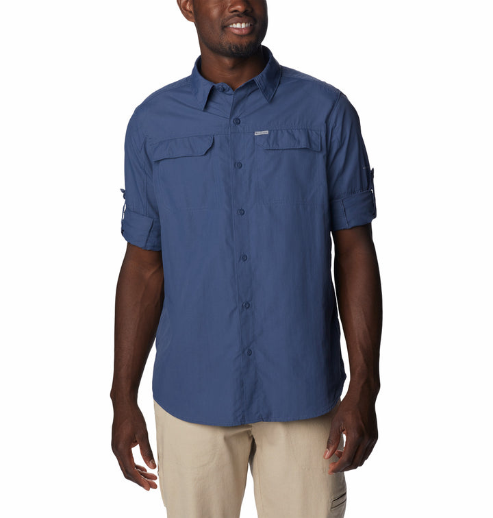 Hombre vistiendo una camisa Columbia de manga larga en color azul oscuro y pantalones color beige.