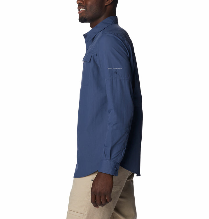 Hombre vistiendo una camisa Columbia de manga larga en color azul oscuro y pantalones color beige.