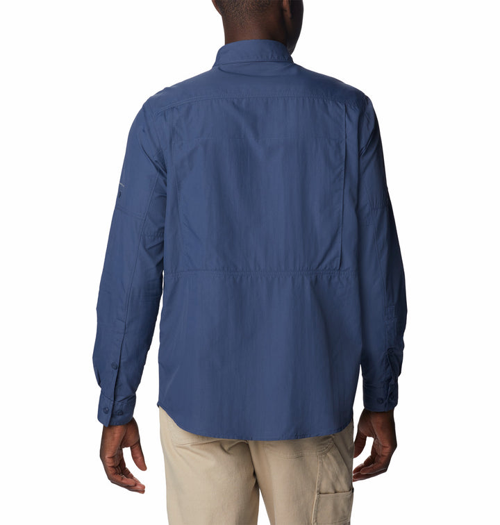 Hombre vistiendo una camisa Columbia de manga larga en color azul oscuro y pantalones color beige.