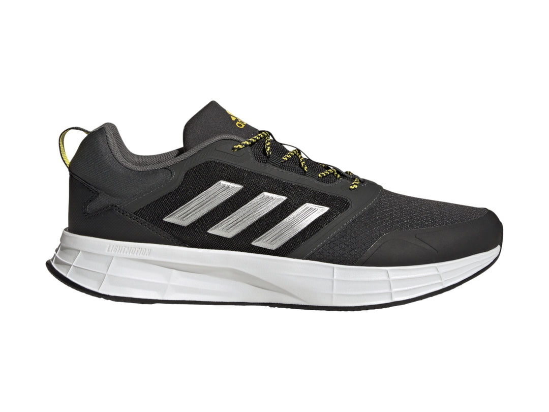 Tenis deportivos Adidas color gris oscuro con franjas plateadas, suela blanca y detalles en amarillo.