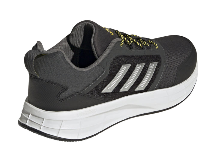 Tenis deportivos Adidas color gris oscuro con franjas plateadas, suela blanca y detalles en amarillo.