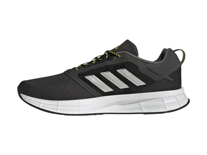 Tenis deportivos Adidas color gris oscuro con franjas plateadas, suela blanca y detalles en amarillo.
