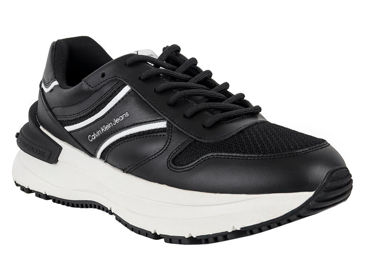 Tenis Calvin Klein Jeans color negro con suela blanca y detalles laterales en blanco.