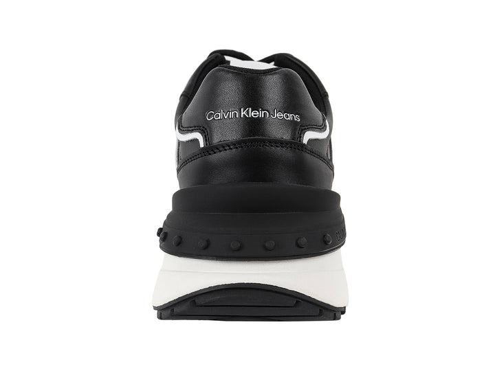 Tenis Calvin Klein Jeans color negro con suela blanca y detalles laterales en blanco.