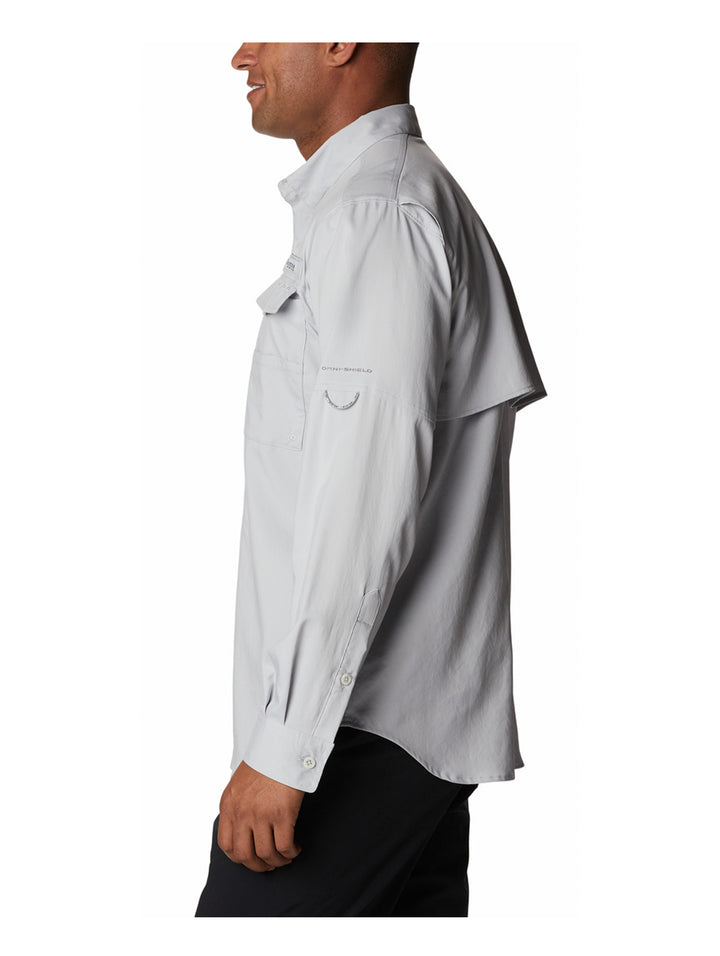 Hombre vistiendo camisa Columbia de color gris claro con mangas remangadas y bolsillos frontales.
