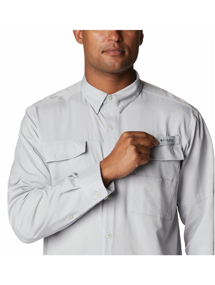 Hombre vistiendo camisa Columbia de color gris claro con mangas remangadas y bolsillos frontales.