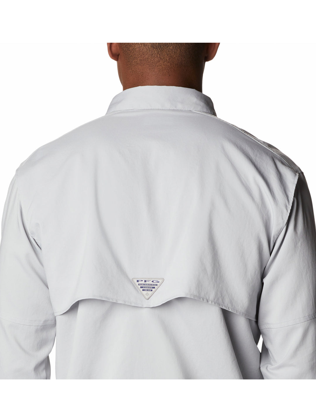 Hombre vistiendo camisa Columbia de color gris claro con mangas remangadas y bolsillos frontales.
