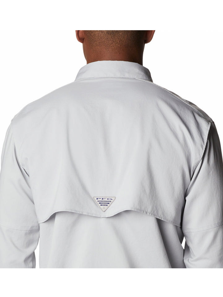 Hombre vistiendo camisa Columbia de color gris claro con mangas remangadas y bolsillos frontales.