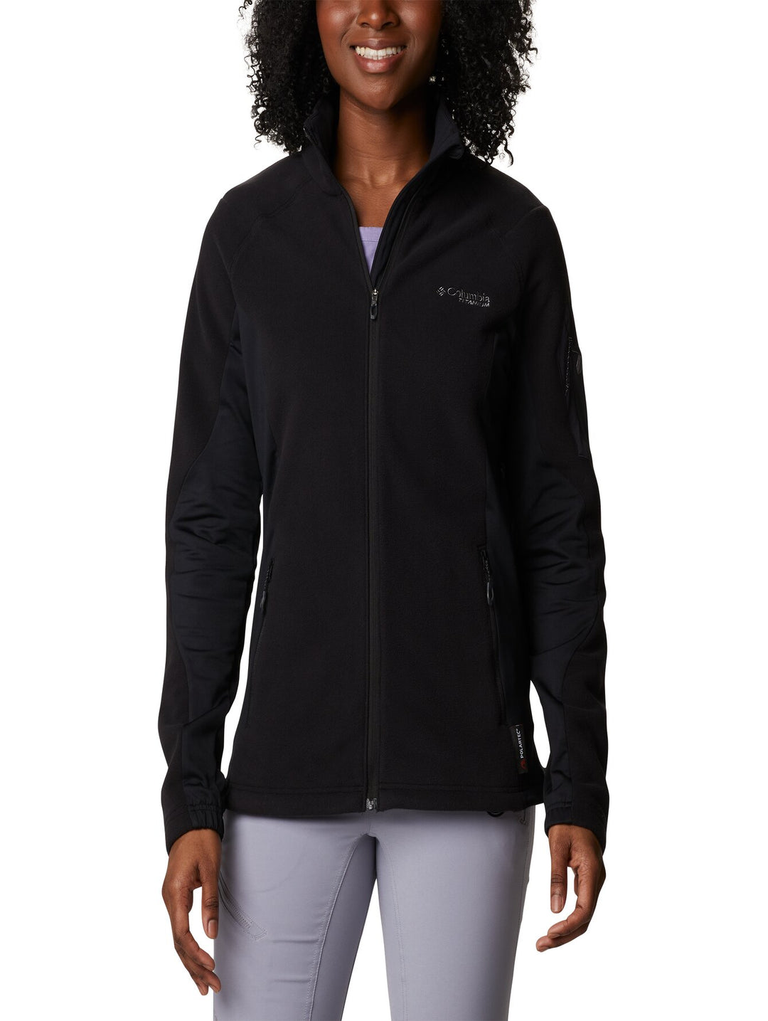 Mujer vistiendo una chaqueta de fleece color negro de la marca Columbia con cierre frontal y cuello alto.