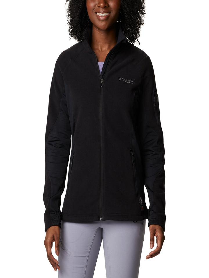 Mujer vistiendo una chaqueta de fleece color negro de la marca Columbia con cierre frontal y cuello alto.