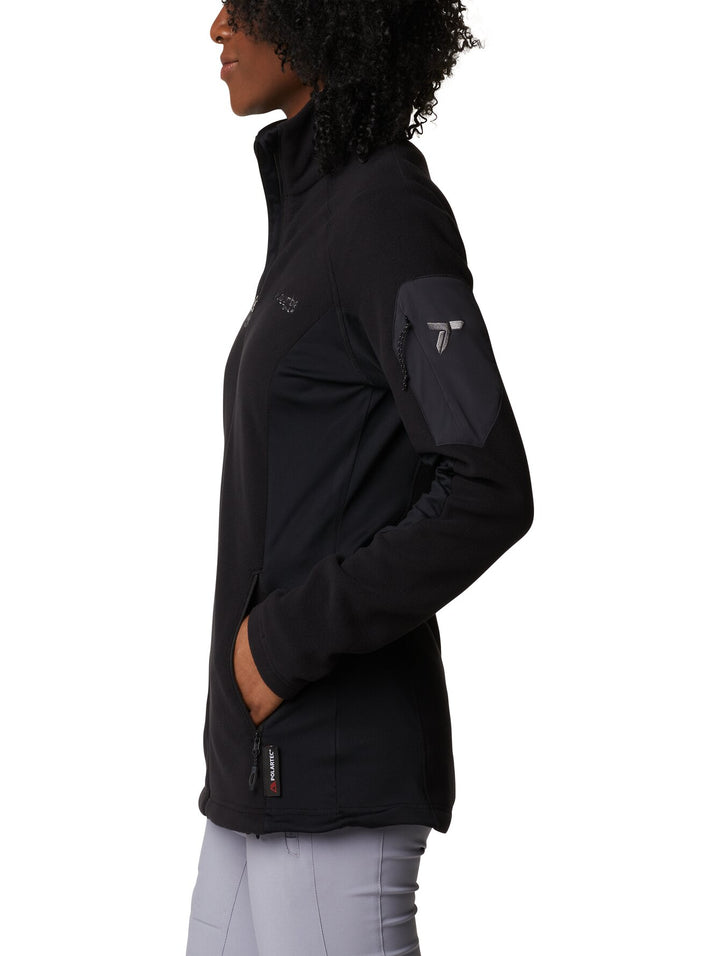 Mujer vistiendo una chaqueta de fleece color negro de la marca Columbia con cierre frontal y cuello alto.