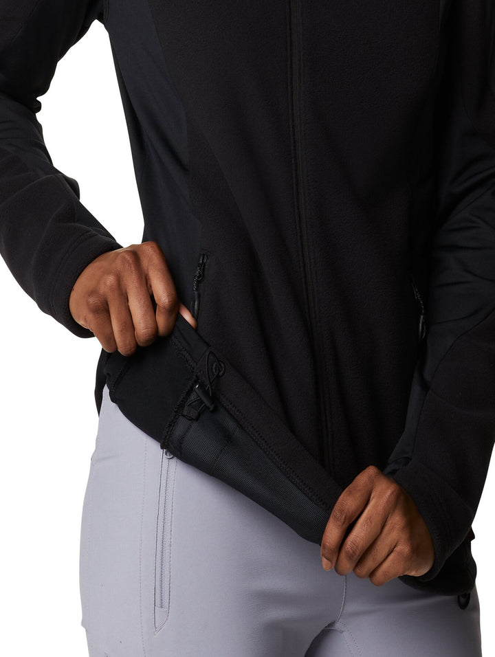 Mujer vistiendo una chaqueta de fleece color negro de la marca Columbia con cierre frontal y cuello alto.