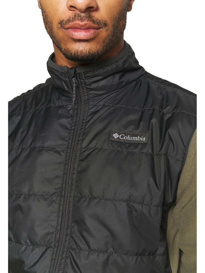 Chaqueta Columbia bicolor verde oliva y negro con panel superior acolchado y cierre frontal.