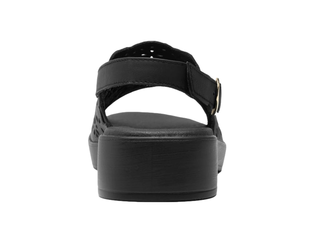 Sandalia negra de cuero con perforaciones florales, plataforma y correa ajustable al tobillo.