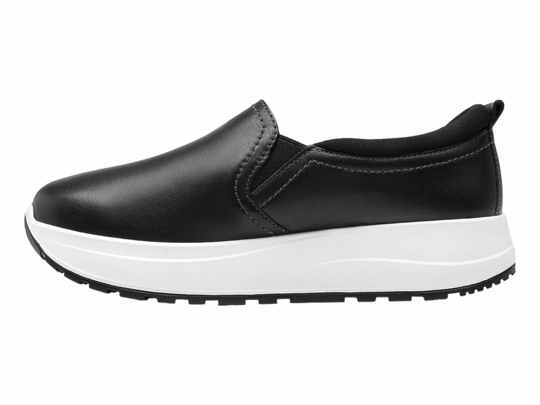 Zapato Flexi slip-on de cuero negro con suela blanca gruesa para mujer.