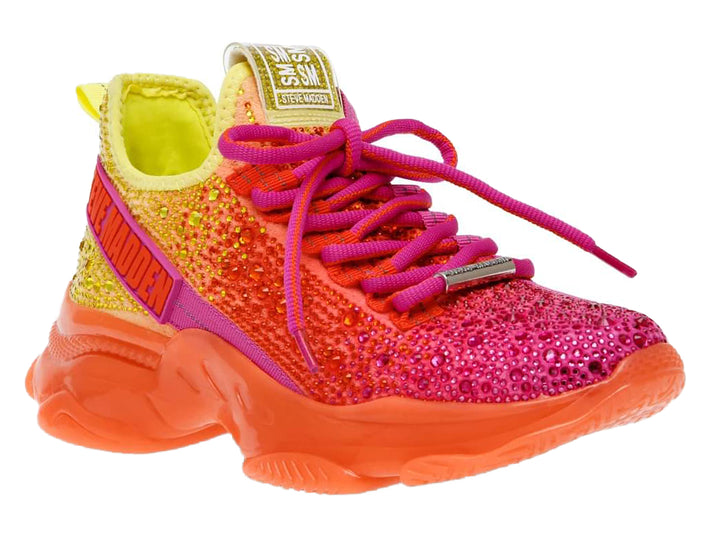 Tenis Steve Madden con degradado de colores amarillo, naranja y fucsia, adornados con cristales y suela gruesa naranja.
