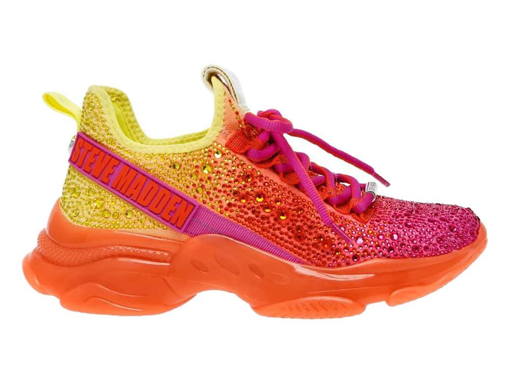 Tenis Steve Madden con degradado de colores amarillo, naranja y fucsia, adornados con cristales y suela gruesa naranja.