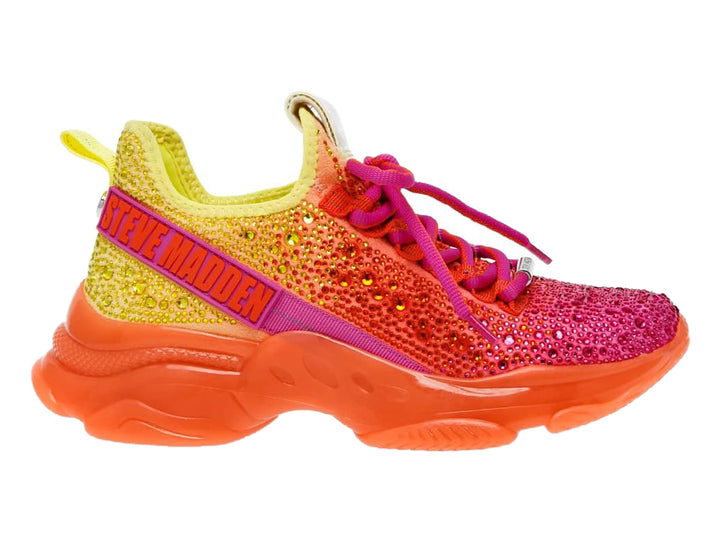 Tenis Steve Madden con degradado de colores amarillo, naranja y fucsia, adornados con cristales y suela gruesa naranja.