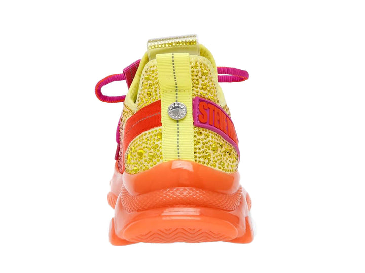 Tenis Steve Madden con degradado de colores amarillo, naranja y fucsia, adornados con cristales y suela gruesa naranja.