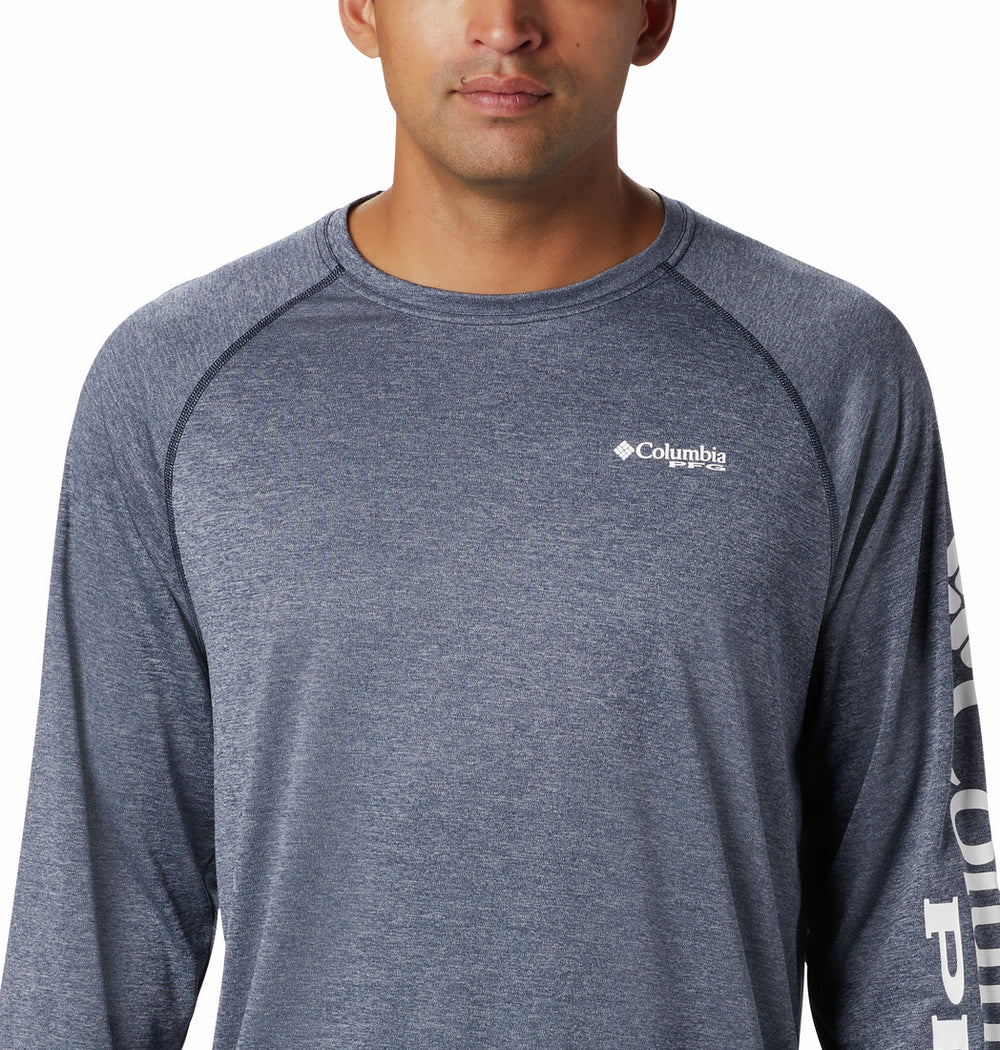 Hombre vistiendo camiseta de manga larga Columbia color azul marino jaspeado con logotipo en la manga.