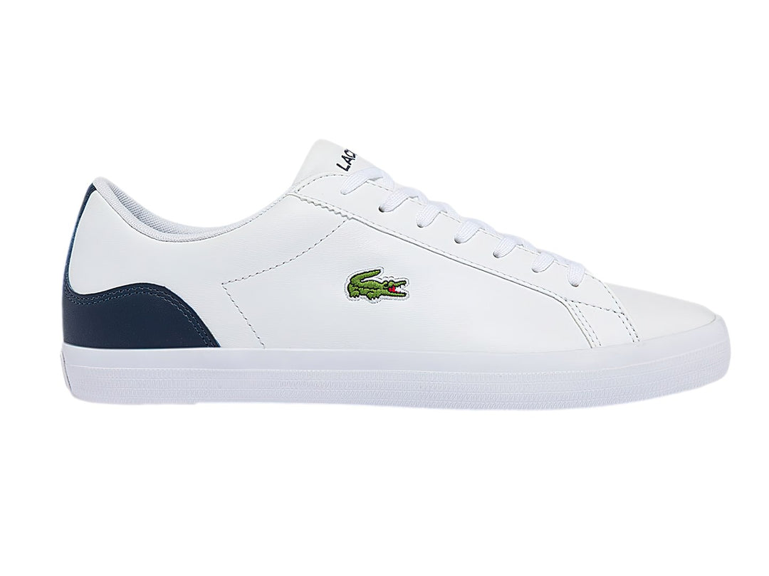 Tenis Lacoste blancos con talón azul marino y logotipo de cocodrilo verde.