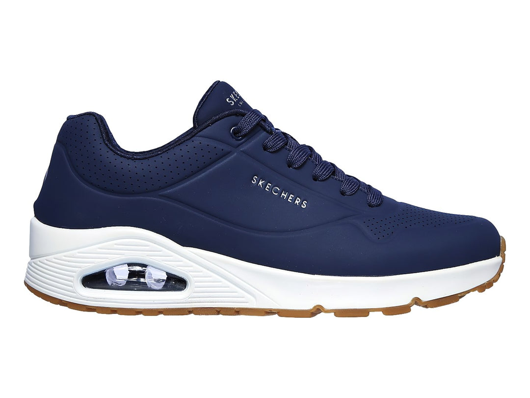 Tenis Skechers color azul marino con suela blanca y amortiguación visible en el talón.